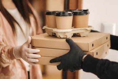 Teslimatçı çocuğu kapat ve müşteriye sipariş ver. Pizza ve kahve devilery. Eldivenli teslimatçı çocuk ve müşteri.