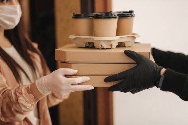 Teslimatçı çocuğu kapat ve müşteriye sipariş ver. Pizza ve kahve devilery. Eldivenli teslimatçı çocuk ve müşteri.