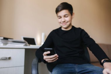 Okul çocuğu tatilde akıllı telefon kullanırmış. Evde ders çalış. Mutlu genç çocuk gülümse