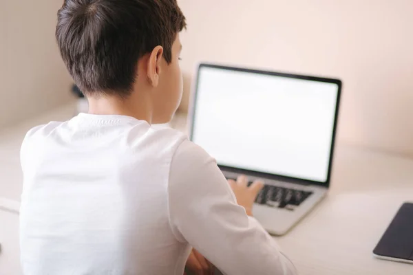 Colegial en casa usando portátil al estudiar. El adolescente hace los deberes en cuarentena. Burla. — Foto de Stock