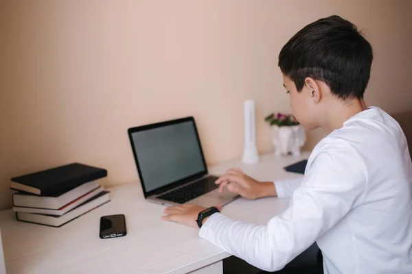 Школьник играет дома в онлайн-игры, пока учится на карантине. Макет ноутбука — стоковое фото