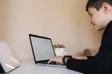 Evde paltipte genç bir çocuk. Genç çocuk evde online oyunlar oynuyor. Karantinada çalış. Qurantine sırasında mutlu okul çocuğu
