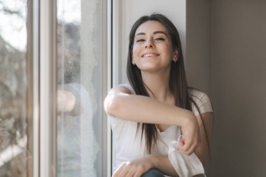 Genç kadın koruyucu maskeni çıkar. Beyaz tişörtlü ve beyaz tıbbi maskeli bir kadın. Karantina sona erdi. Coronavirus teması