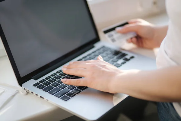 Закрытие покупок молодой женщины в Интернете с помощью ноутбука и кредитной карты. Ноутбук на подоконнике — стоковое фото