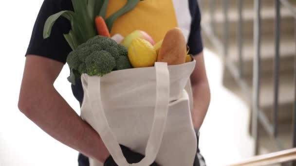 Entrega homem em máscara e luvas trazer alimentos frescos para os clientes em casa. Fica em casa. Conceito de compras online — Vídeo de Stock