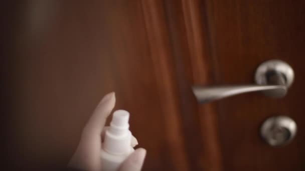 Detailní záběr mladé ženy, jak otírá kliku dveří o povrch antibakteriálním dezinfekčním tampónem. Samice zabíjející virus korony pomocí antiseptika. Coronavirus COVID-19 — Stock video
