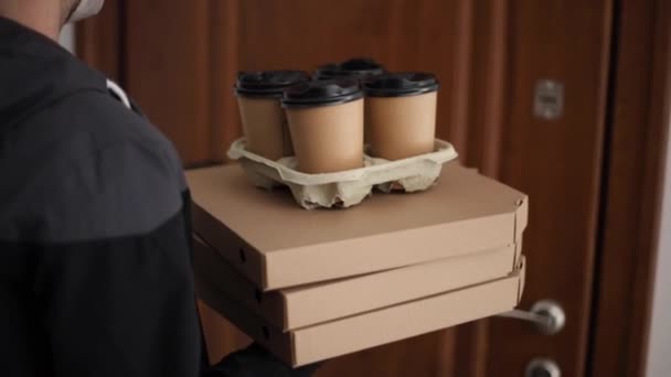 Close up of man hold tree boxes of pizza. Man delivery food and coffe to customer in mask and gloves. Coronavirus theme — Stock Video