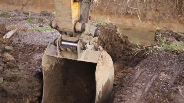 Escavadeira escavar e despejar na pilha de sujeira. Pinças no guindaste carregam materiais de construção. Substâncias soltas. Contexto da floresta — Vídeo de Stock