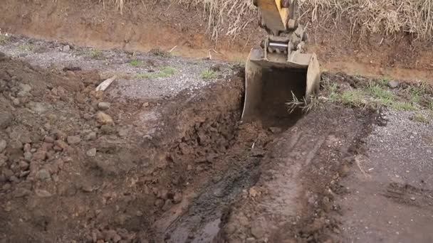 Excavator scooping and dumping on dirt pile. Tongs on the crane carry construction materials. Loose substances. Background of forest — Stock Video