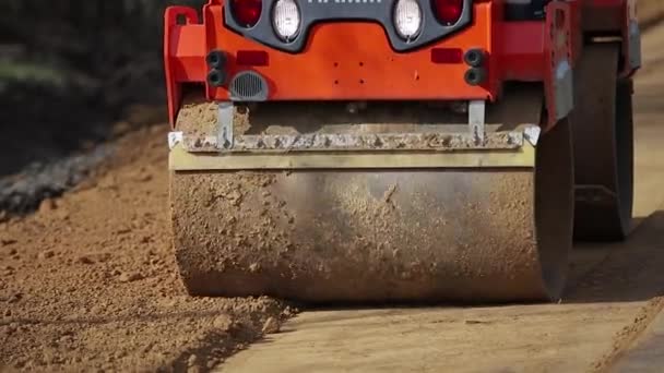 El pavimentador se mueve en un lugar de preparación de tierra para la nueva carretera, embestida y nivelación — Vídeos de Stock