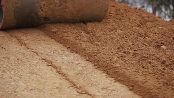 El pavimentador se mueve en un lugar de preparación de tierra para la nueva carretera, embestida y nivelación — Vídeos de Stock