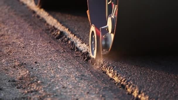 Yeni yapılmış düz bir yolda kaldırım taşıma aracı, çarpıyor ve düzleştiriyor. Asfalt kaldıracı tamir edilen şehir yoluna asfalt uyguluyor — Stok video