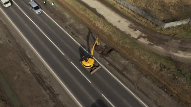 Aerial view of Excavator scooping and dumping on dirt pile. Tongs on the crane carry construction materials — Stock Video