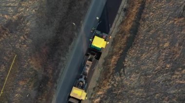 Farklı makinelerin insansız hava aracı görüntüleri yolu inşa ediyor. Kazıcı, minibüs, kamyon.