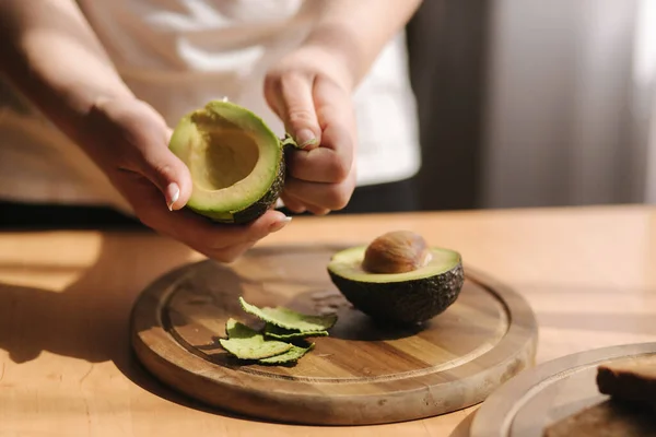 Middle selection of female pill an avocado on wooden board at home. Vegetarian food concept — Stock Photo, Image