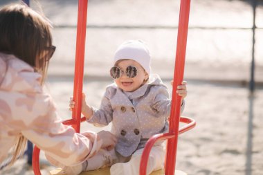 Çocuk parkında salıncakta sallanan sevimli küçük kız. Mutlu küçük kız iyi eğlenceler. Bir ve Hulk yılı kızı.