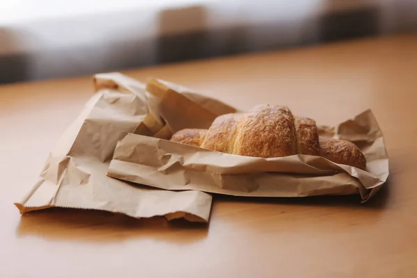 Sroissant na drewnianym stole. Dzień dobry w domu. — Zdjęcie stockowe