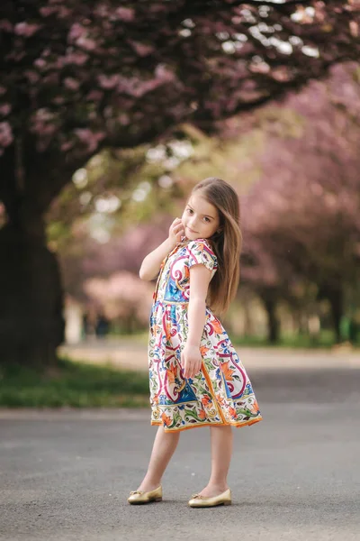 Молода дівчина-модель позує фотографу. Жіноча дитина я красива сукня зовні — стокове фото