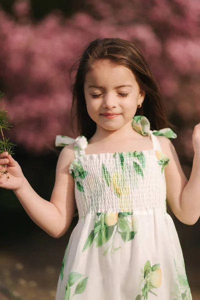 Портрет чарівної дівчинки на свіжому повітрі, що йде в парку, на фоні дерева сакури — стокове фото