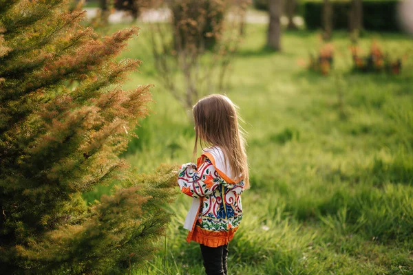 Côté petite fille debout près d'un grand pin — Photo