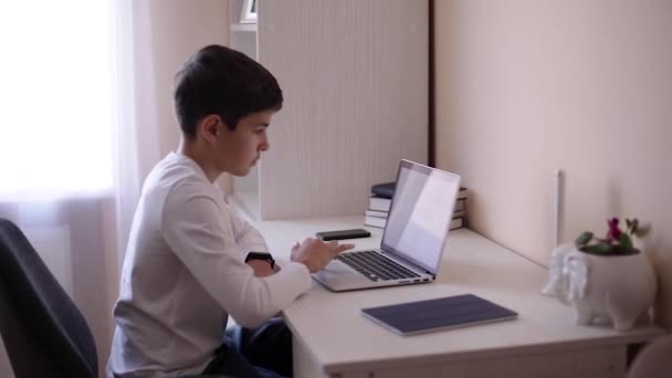 Estudante em casa usando laptop ao estudar. O adolescente faz trabalhos de casa em quarentena. Mockup — Vídeo de Stock