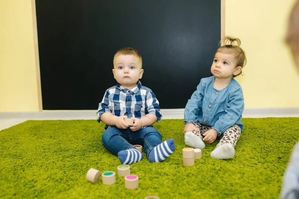 Los niños en preescolar juegan con cubos. Niños pequeños felices — Foto de Stock