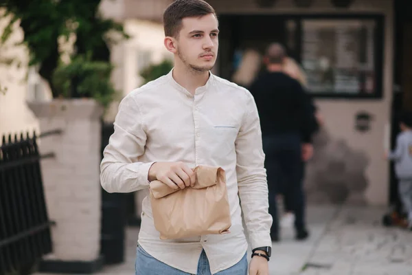 Young man take fresh food from vegan caffe outdoor — Stock Photo, Image