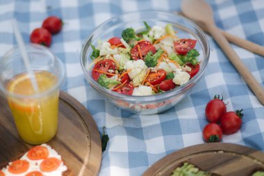Açık havada taze vejetaryen salatası ve mavi peçete. Vejetaryen yemek konsepti.
