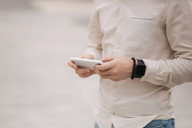 Şehrin merkezinde telefonunu kullanan yakışıklı bir genç adam var. Adam dışarıda online oyun oynuyor. Orta seçim