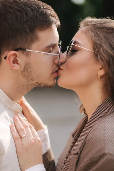 Close up portrait of two people kissing each other outdoors. Beautiful couple of handsome man and attractive young woman with curly hair. Side view — Stock Photo, Image