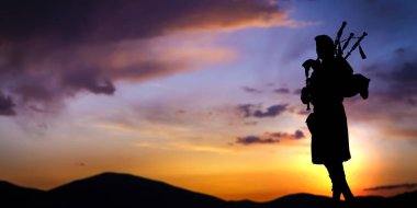 Bagpipe player in silhouette over sunset clipart