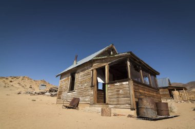 Terk edilmiş hayalet kasaba ev veya baraka altında Nevada Çölü'nde açık mavi gökyüzü.