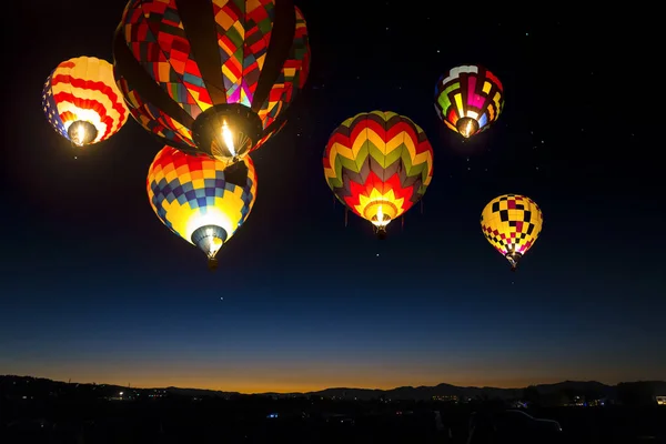 Coloridos globos de aire caliente al amanecer iluminados en el cielo . —  Fotos de Stock