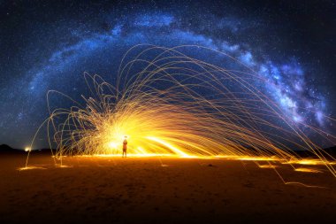 Arched Milky Way and Fiery Sparks on desert lake bed clipart