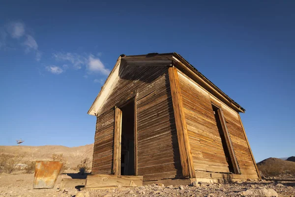 Velha barraca abandonada em Rhyolite Ghost Town no deserto de Nevada em luz da manhã cedo com céu azul claro . — Fotografia de Stock