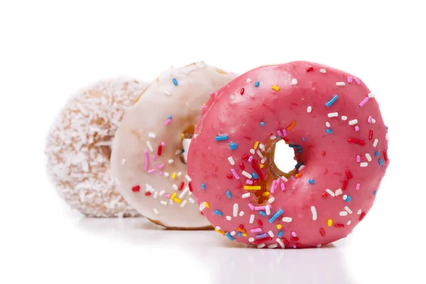 Three donuts isolated on White Background. Pink, Frosted and Coconut with sprinkles. — Stock Photo, Image