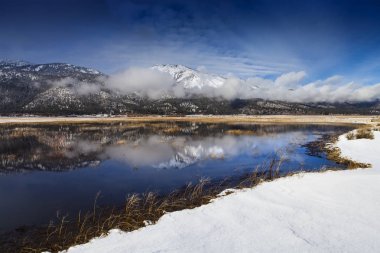 Washoe Valley, Nevada. Pond reflection and slide mountain in winter with snow. clipart