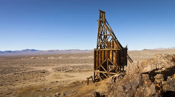 Oude houten mijnbouw hopper bin onder blauwe lucht in de Nevada-woestijn in de buurt van een spookstad. — Stockfoto