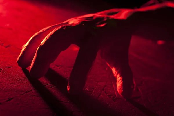 Creepy crawling hand in red light inside a haunted house. Halloween prop. — Stock Photo, Image