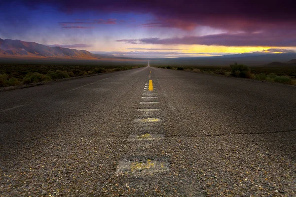 Roadway leading off to the horizon during sunrise in the Nevada Desert