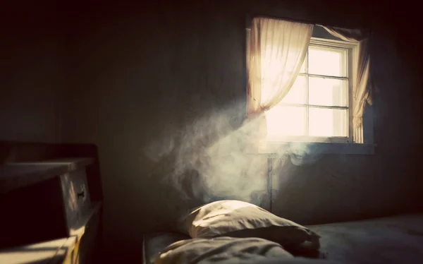 Vintage tratado antigo quarto abandonado com fumaça iluminada por uma janela aberta com cortinas — Fotografia de Stock
