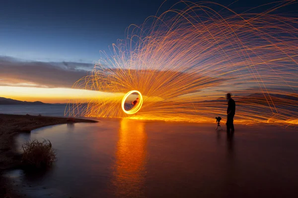 Fotografo in lago ripresa foto di scintille filanti al tramonto. Lago delle Piramidi, NV . — Foto Stock