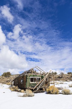 Eski hayalet kasaba binalar çölde kar ile kış aylarında yıpranmış. Ione, Nevada
