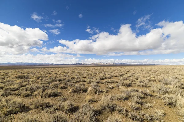 Paysage désertique vide grand ouvert dans le Nevada pendant l'hiver avec ciel bleu et nuages. Montagnes au loin . — Photo