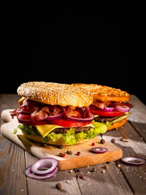 Pastırmalı hamburger ve ahşap masa.