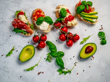 Hafif arka planda farklı lezzetli bruschettalar, düz bir zemin. Üst görünüm
