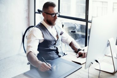 Sakallı Grafik Tasarımcı Çalışma Dijital Tablet Çizim Masaüstü Bilgisayar Ahşap Masa.Şık Genç Adam Gözlük Beyaz Gömlek Yelek İş Modern Loft Yaratıcı Başlangıç Projesi Bulanık Yatay