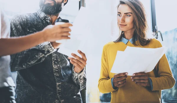 Jongeren discussiëren over zakelijke ideasin een kantoor. Man zijn handen van het papier te houden en in gesprek met een vrouw. Horizontale, wazig. — Stockfoto