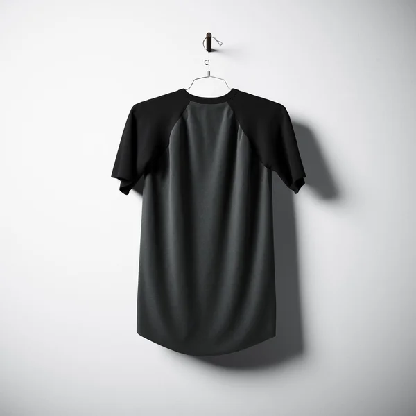Pusty bawełniany Tshirt z czarno-szarymi kolorami wiszącymi w środku pustej betonowej ścianie. Przezroczysta etykieta z wysoce szczegółowym materiałem teksturowanym. Placu. Widok z boku. Renderowanie 3D. — Zdjęcie stockowe