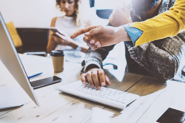 İş arkadaşlarınızla birlikte güneşli bir ofiste çalışan grubudur. Ahşap masa, bilgisayar klavye yazarak adam. Masaüstü ekran için işaret eden el. Yatay görüntü bulanık,.